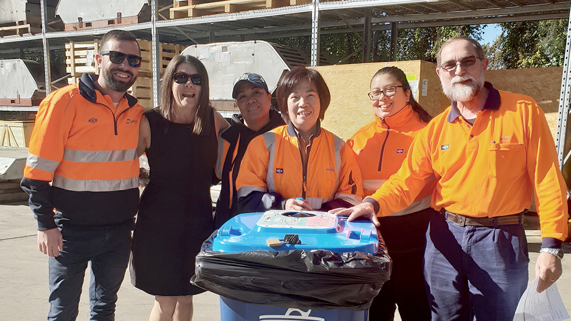 Group of smiling employees in safety gear.