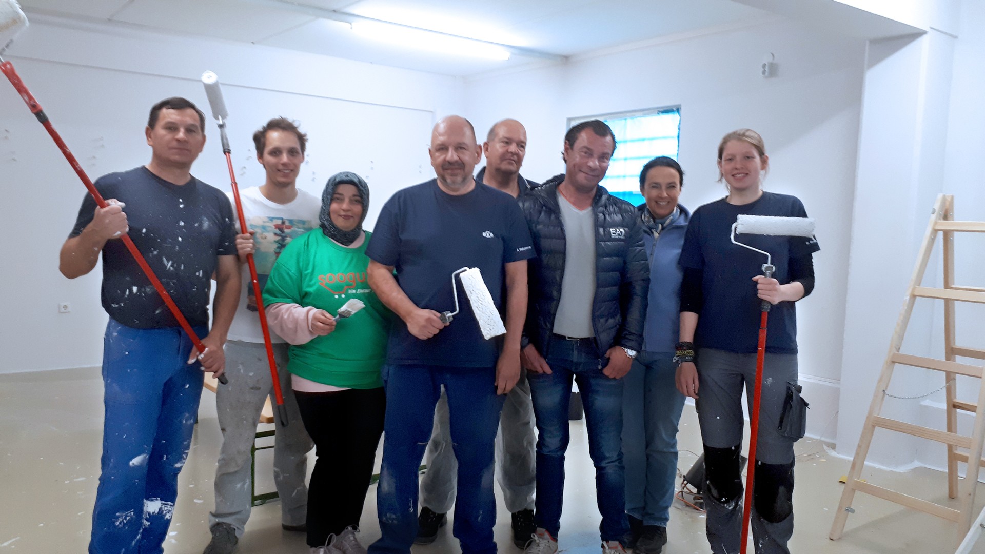 Group of people painting interior space together