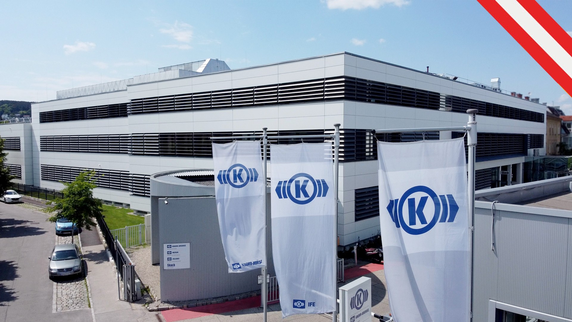 Knorr-Bremse office building with branded flags displayed.