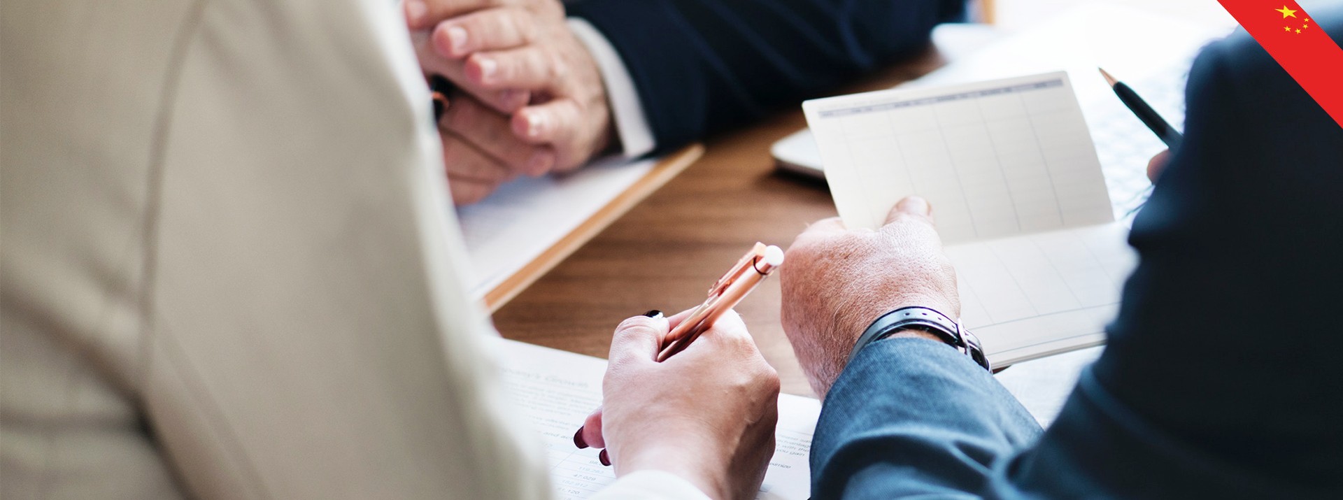 Business meeting with hands and notepad visible.