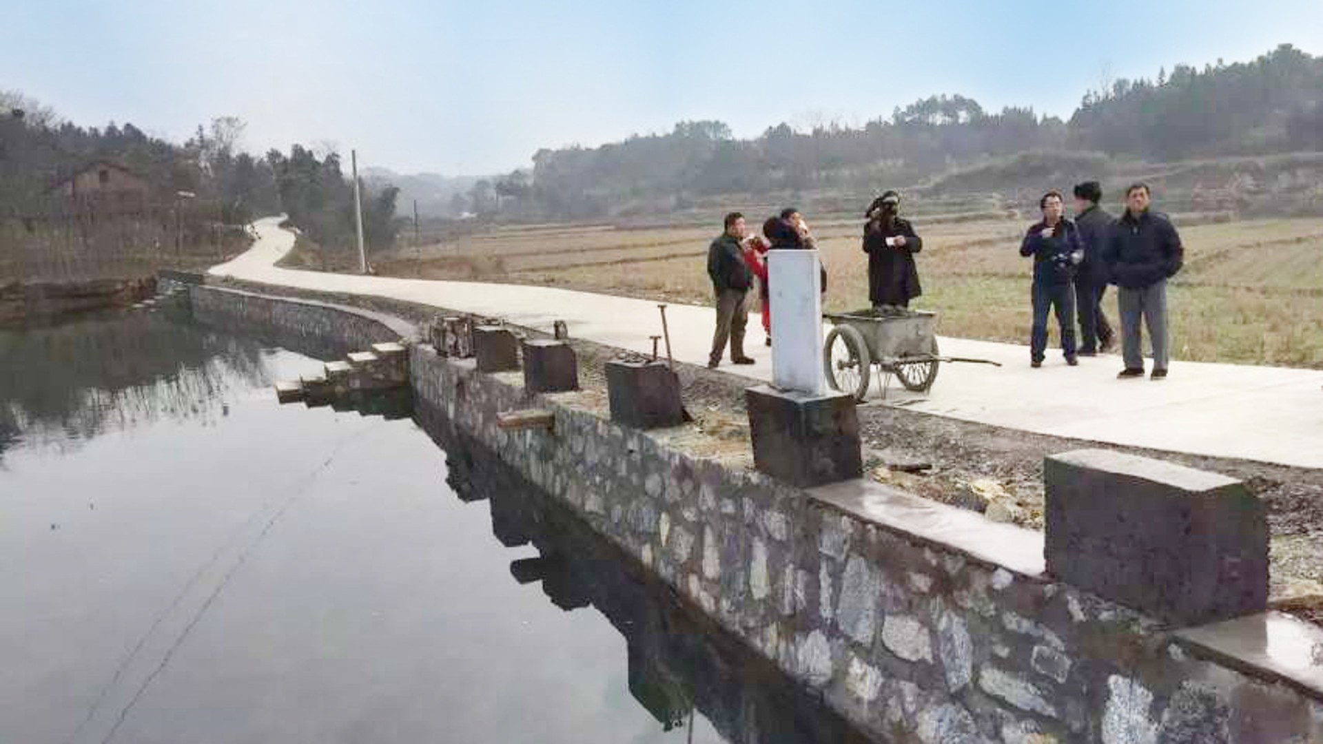 Group of people by rural waterway and
