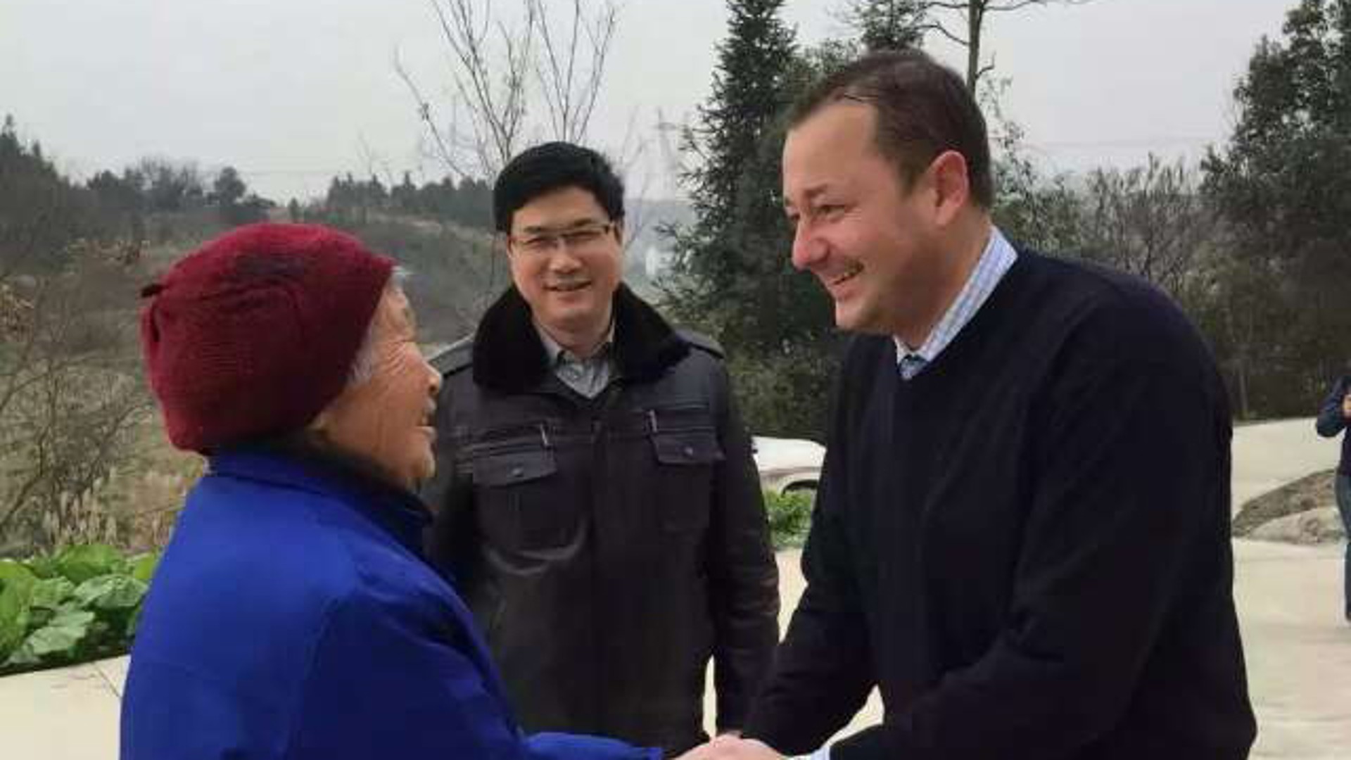 Greeting between man and elderly woman outdoors