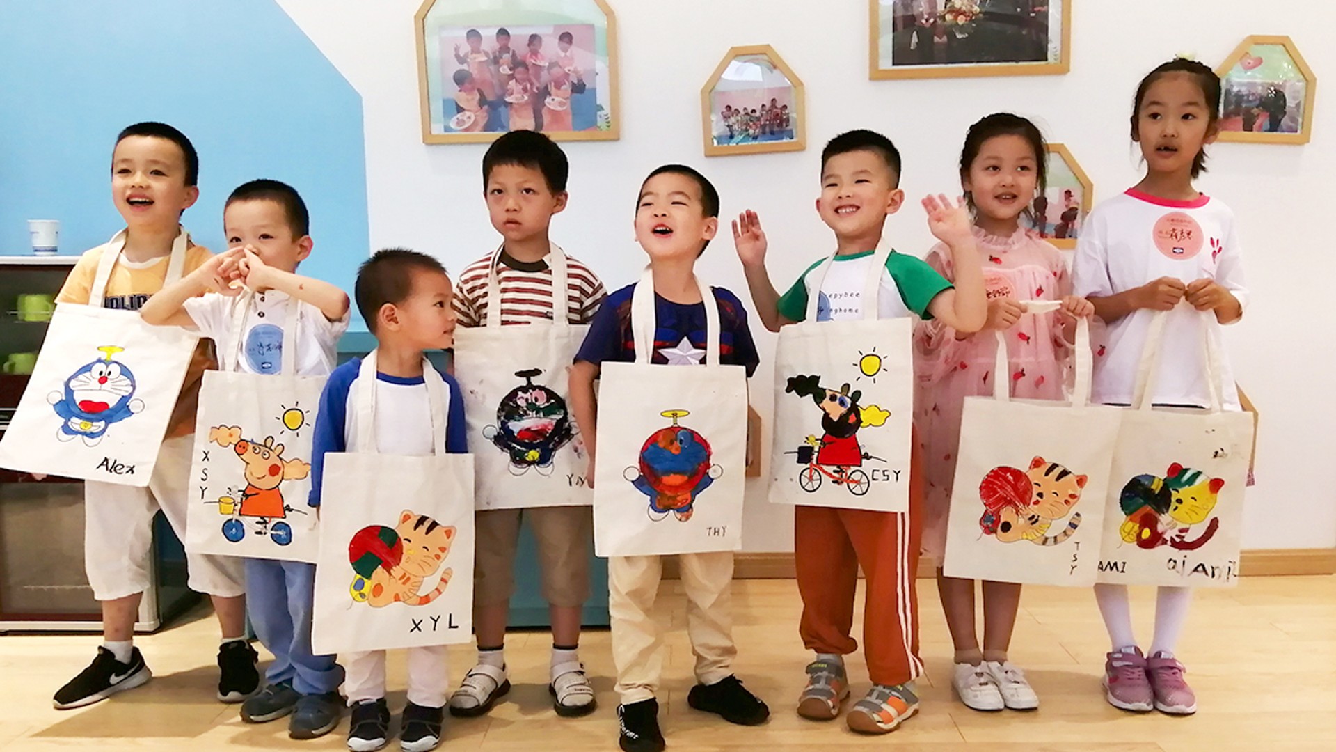 Children holding art tote bags in classroom