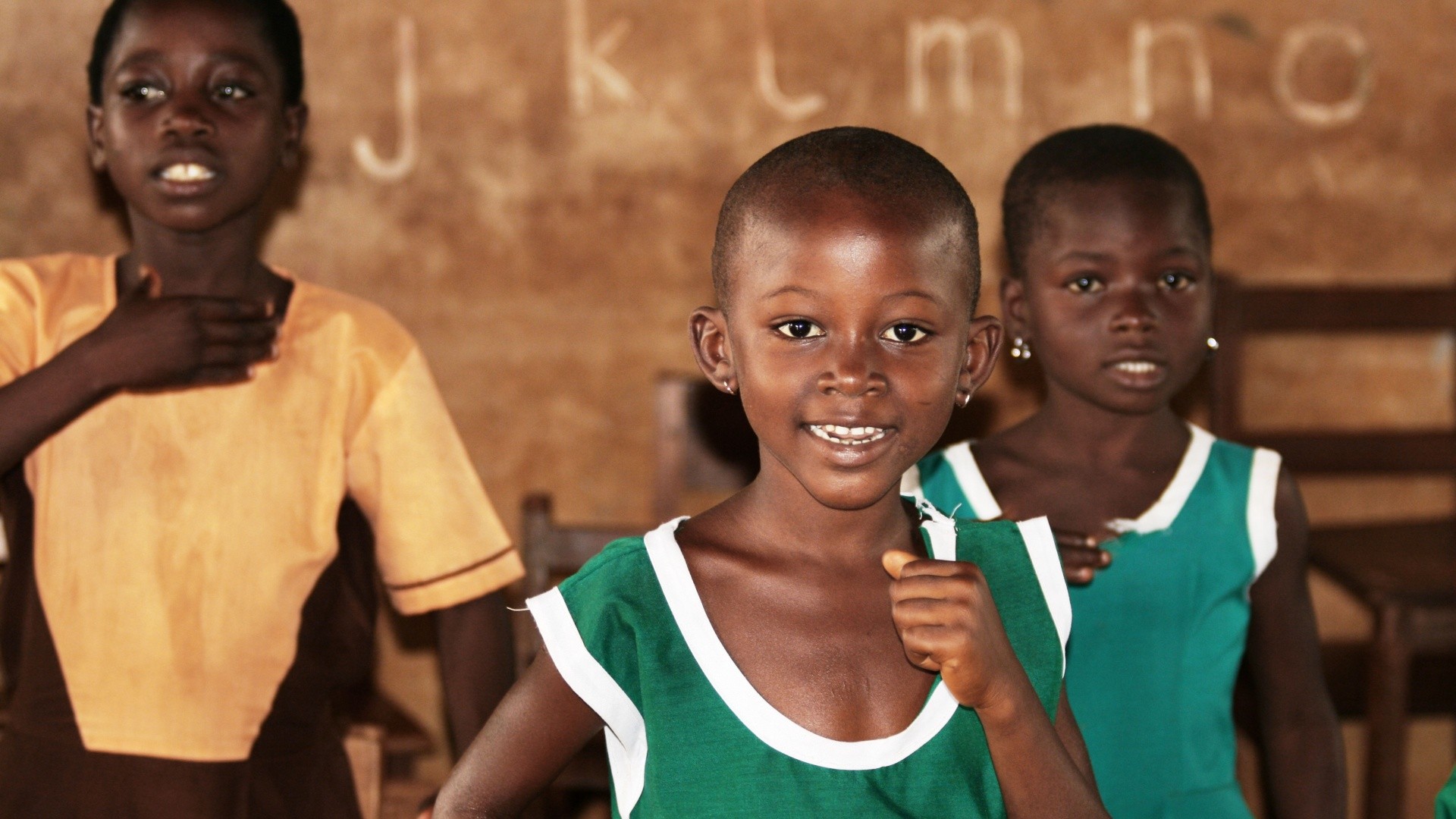 Children singing in a classroom setting.