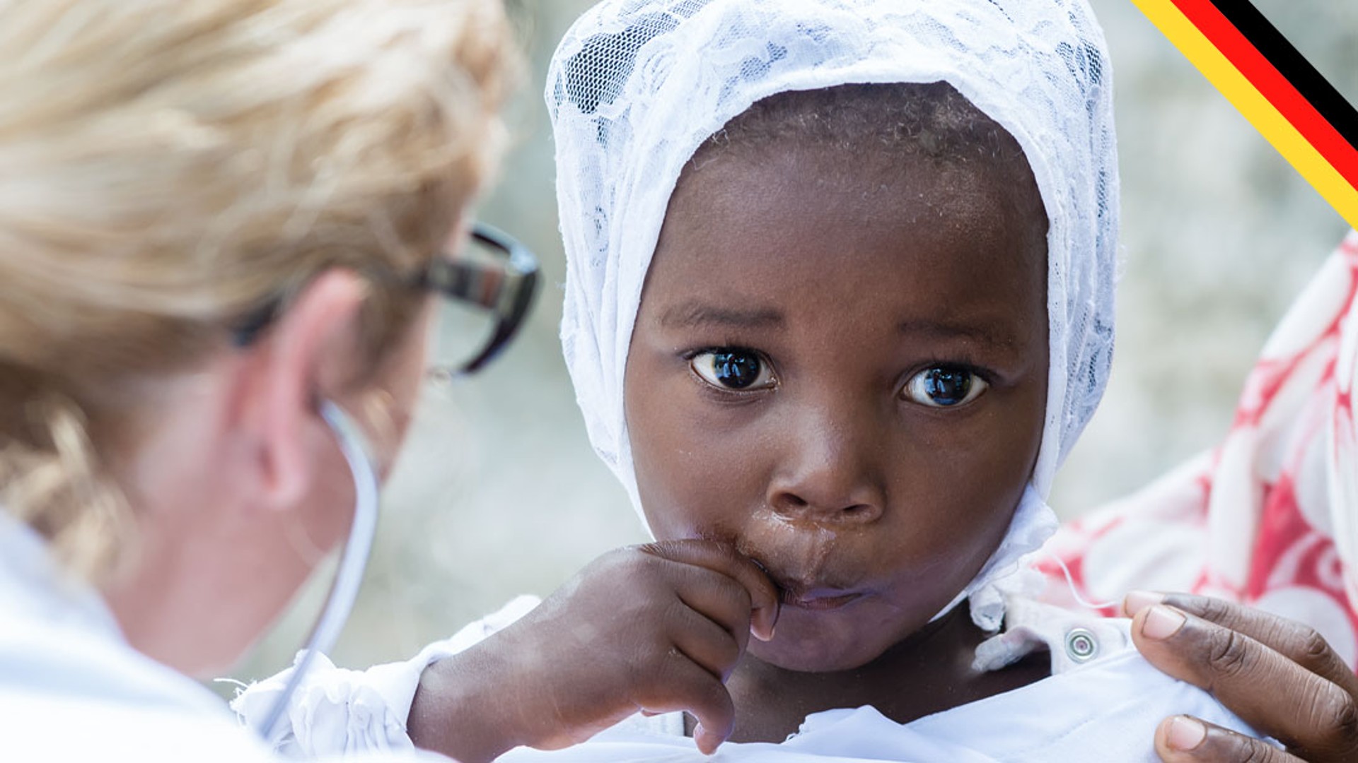 Child receiving medical care with concerned expression.