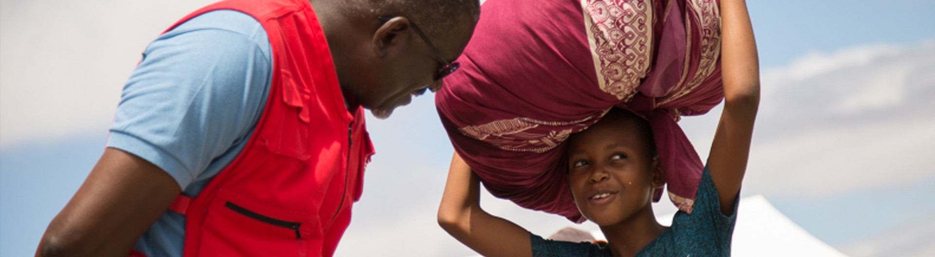Man and girl interacting outdoors with basket.