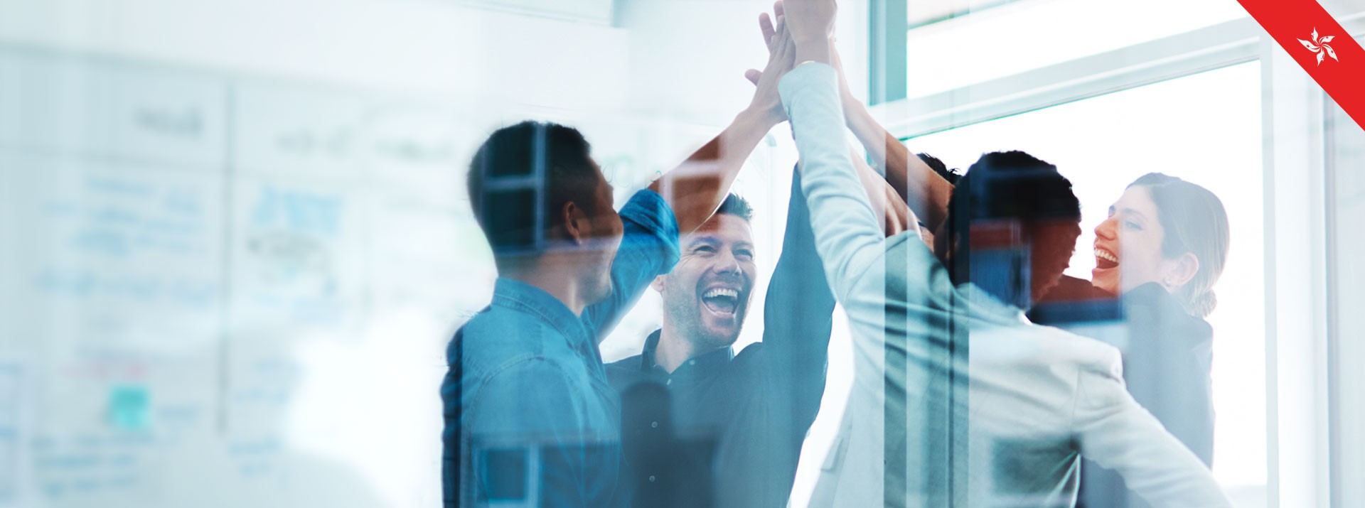 Team celebrating success with high-fives indoors.