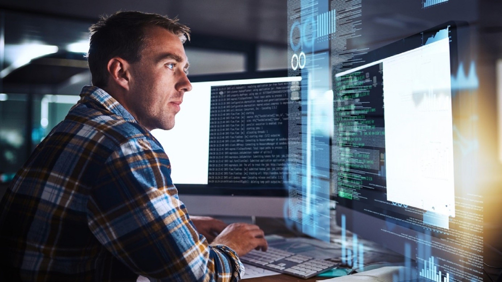 Man coding with multiple computer screens displaying