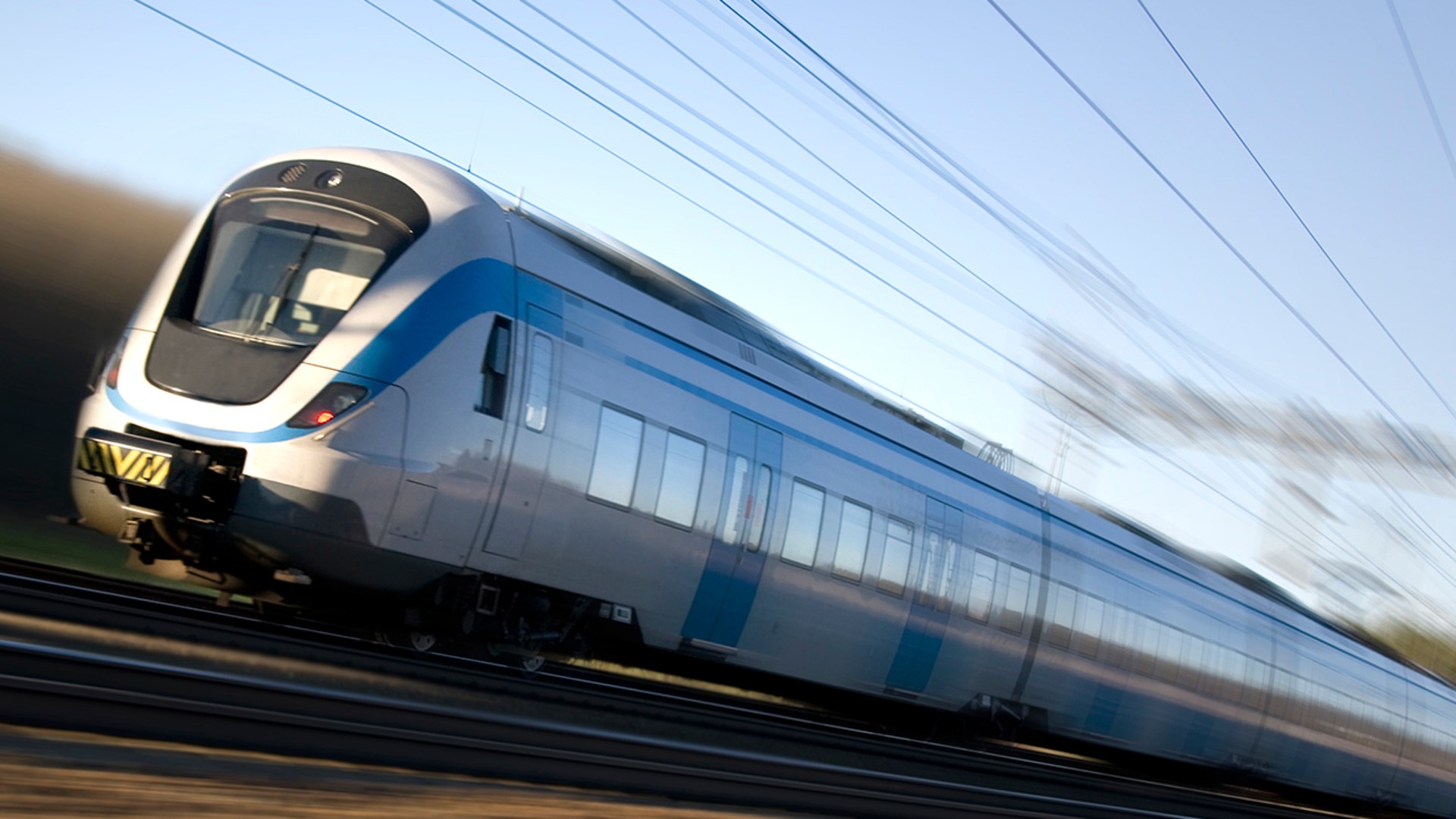 High-speed train in motion on railway tracks.
