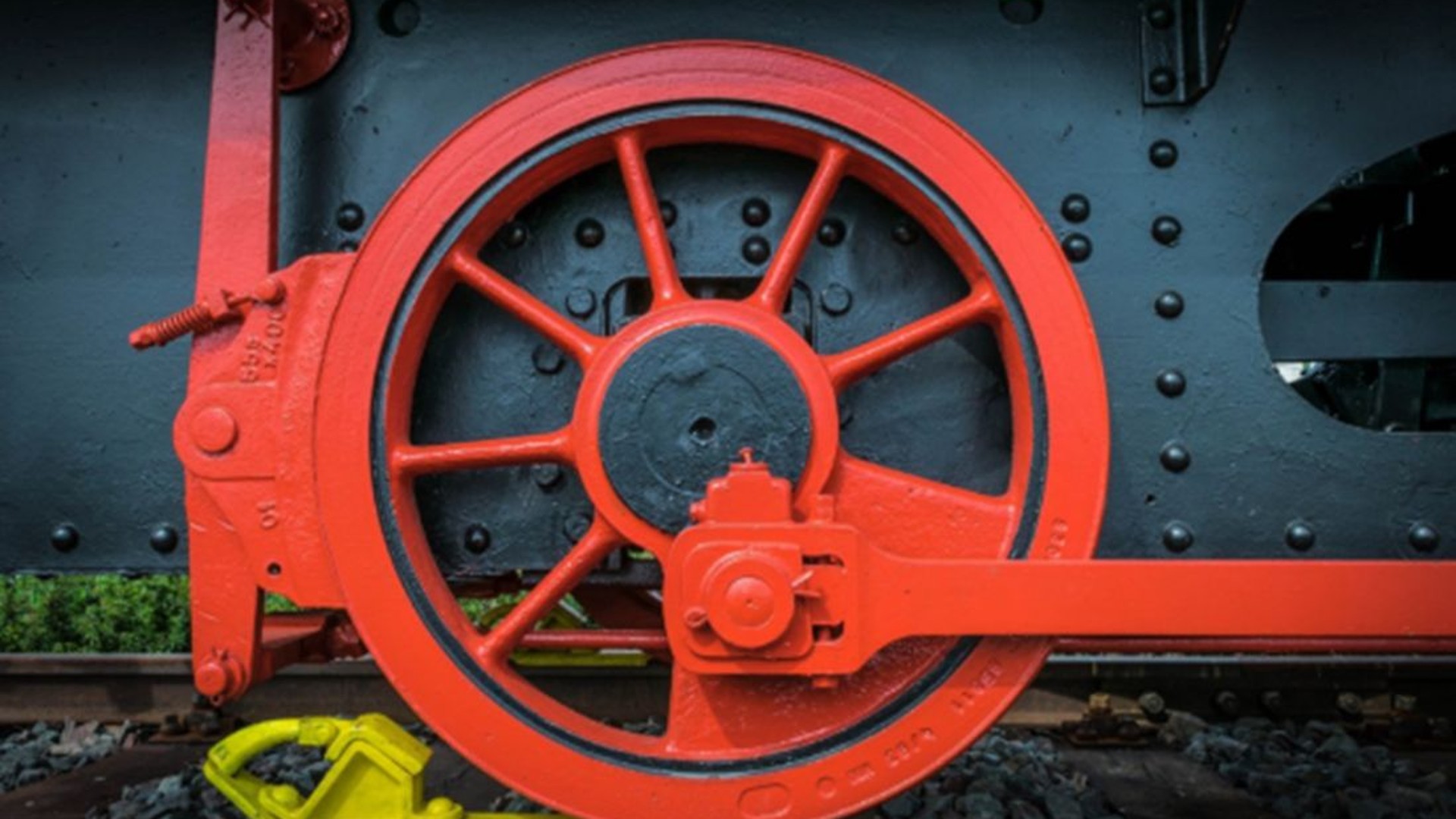 Red train wheel on railroad tracks, industrial