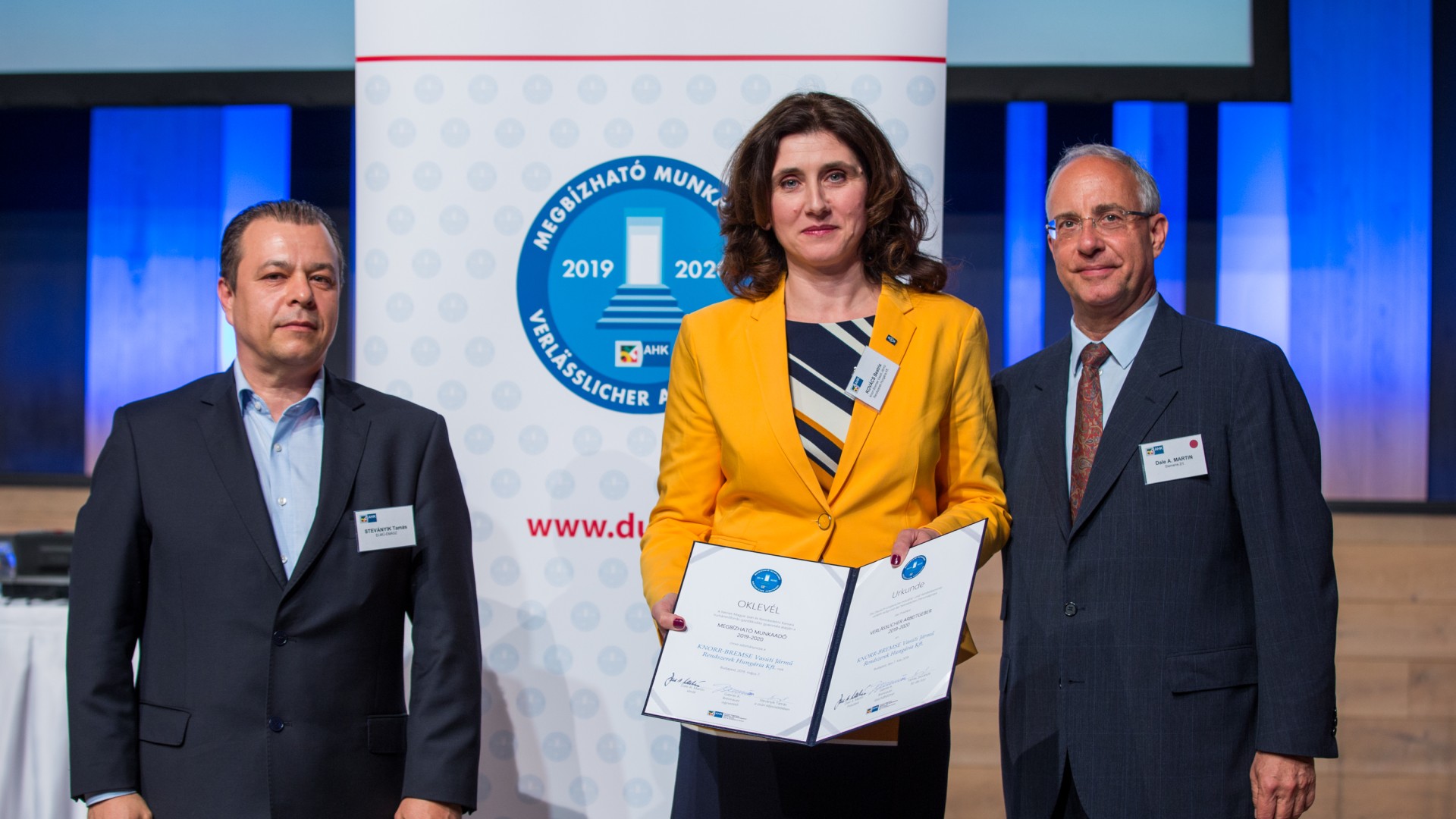 Business event with award recipients and certificates.