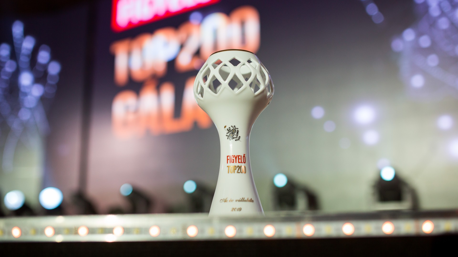Figyelő Top200 award on a gala stage.
