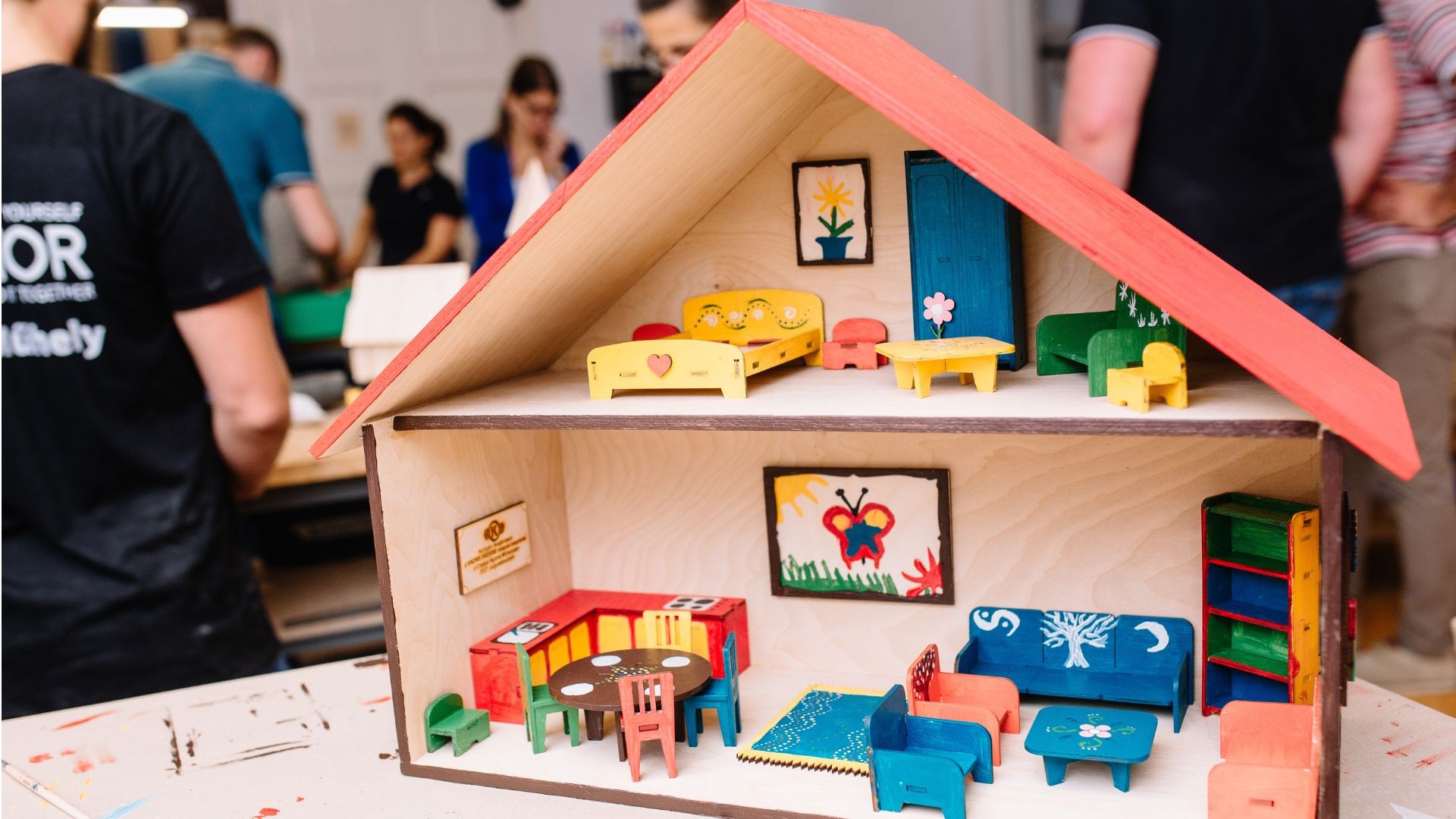 Colorful miniature dollhouse with detailed furniture setup.