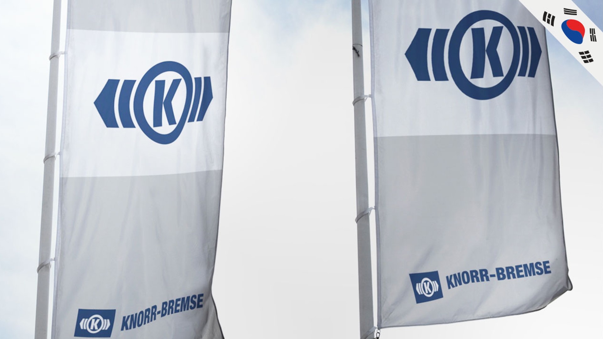 Knorr-Bremse flags displayed against a cloudy sky.