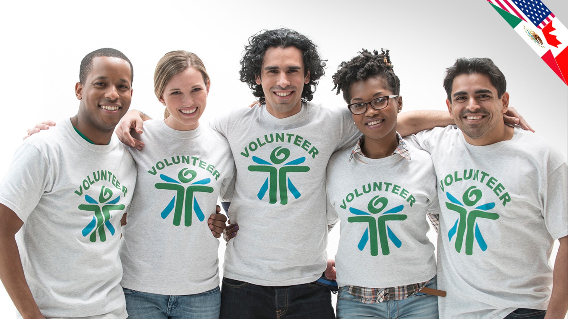 Diverse volunteers wearing matching shirts, smiling together.