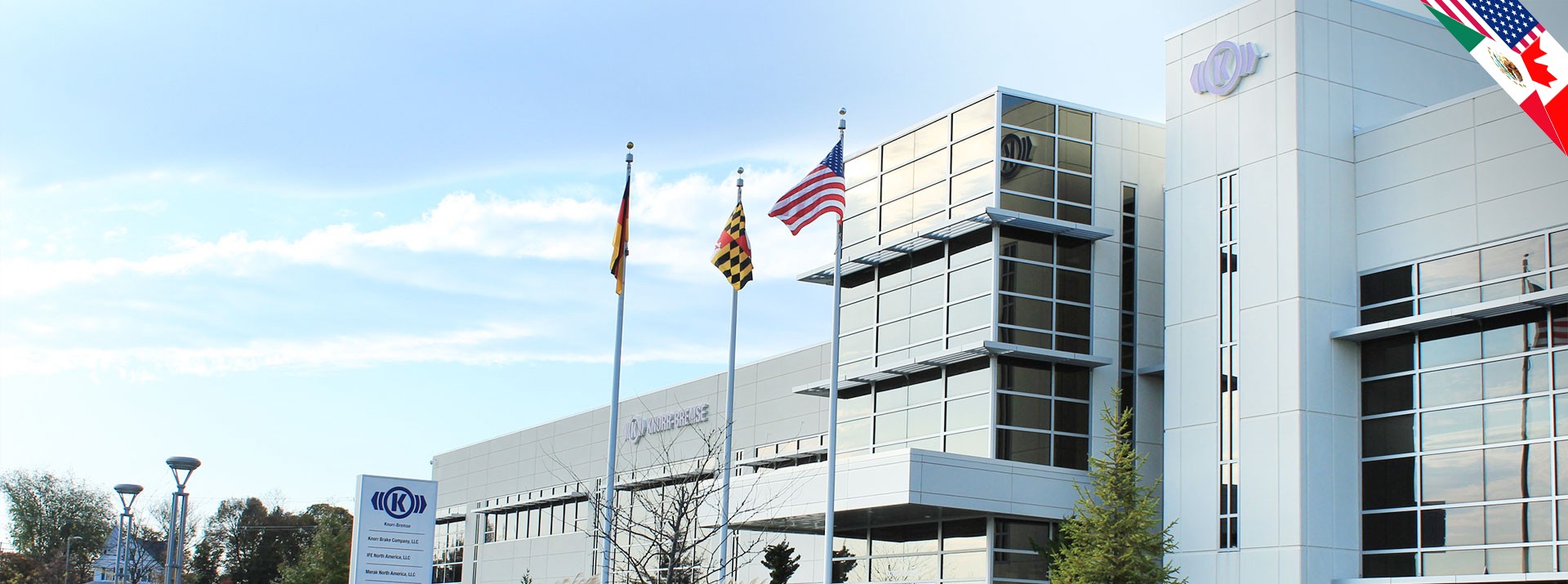 Knorr-Bremse building with flags and clear sky.
