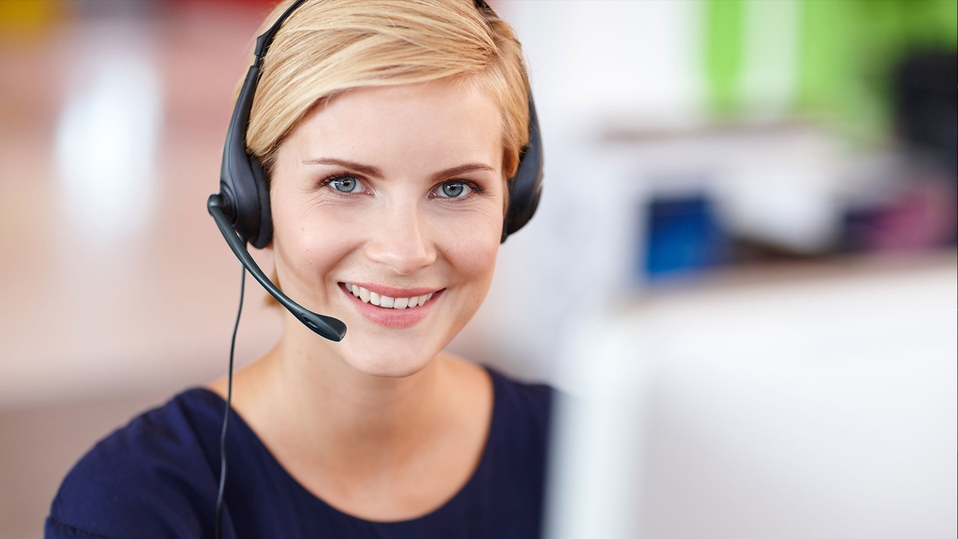 Smiling woman wearing headset in office environment.
