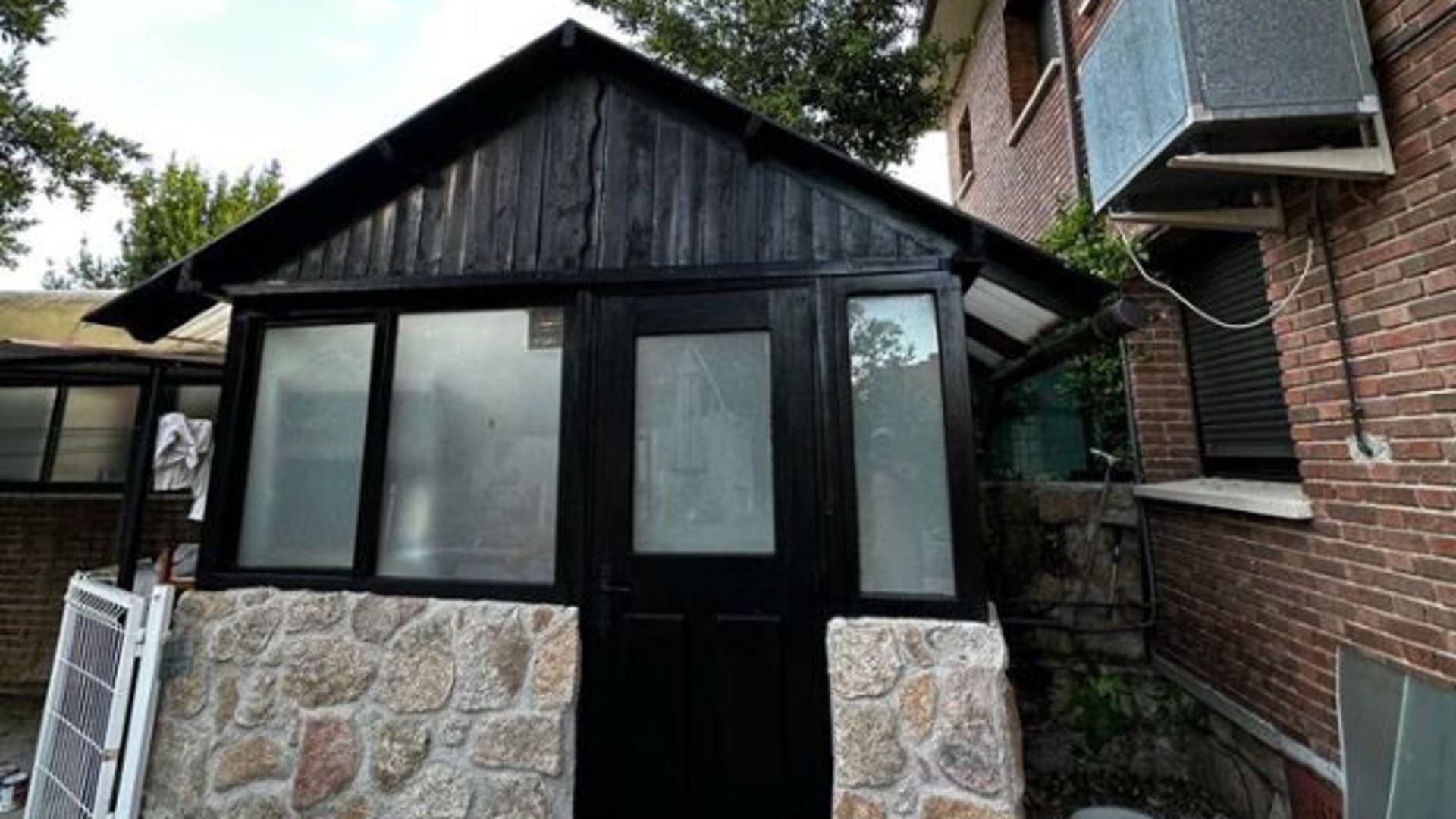 Black wooden structure with stone base and
