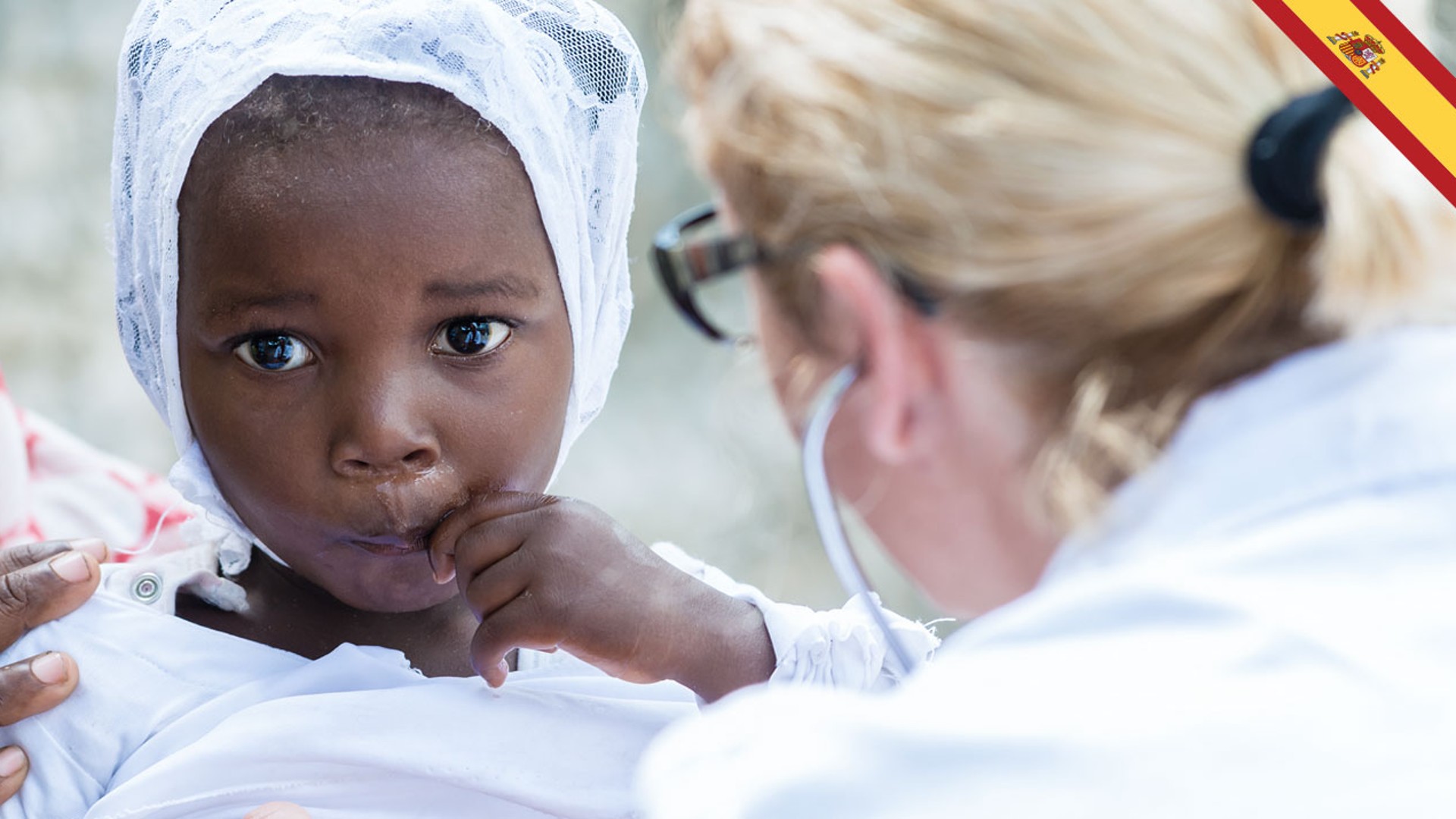 Child in white attire being examined by