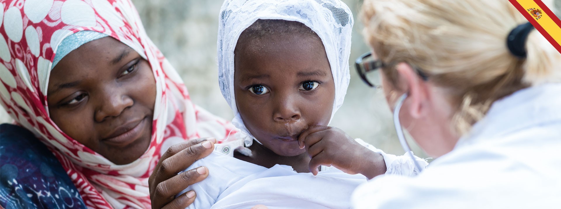 Child in white attire being examined by