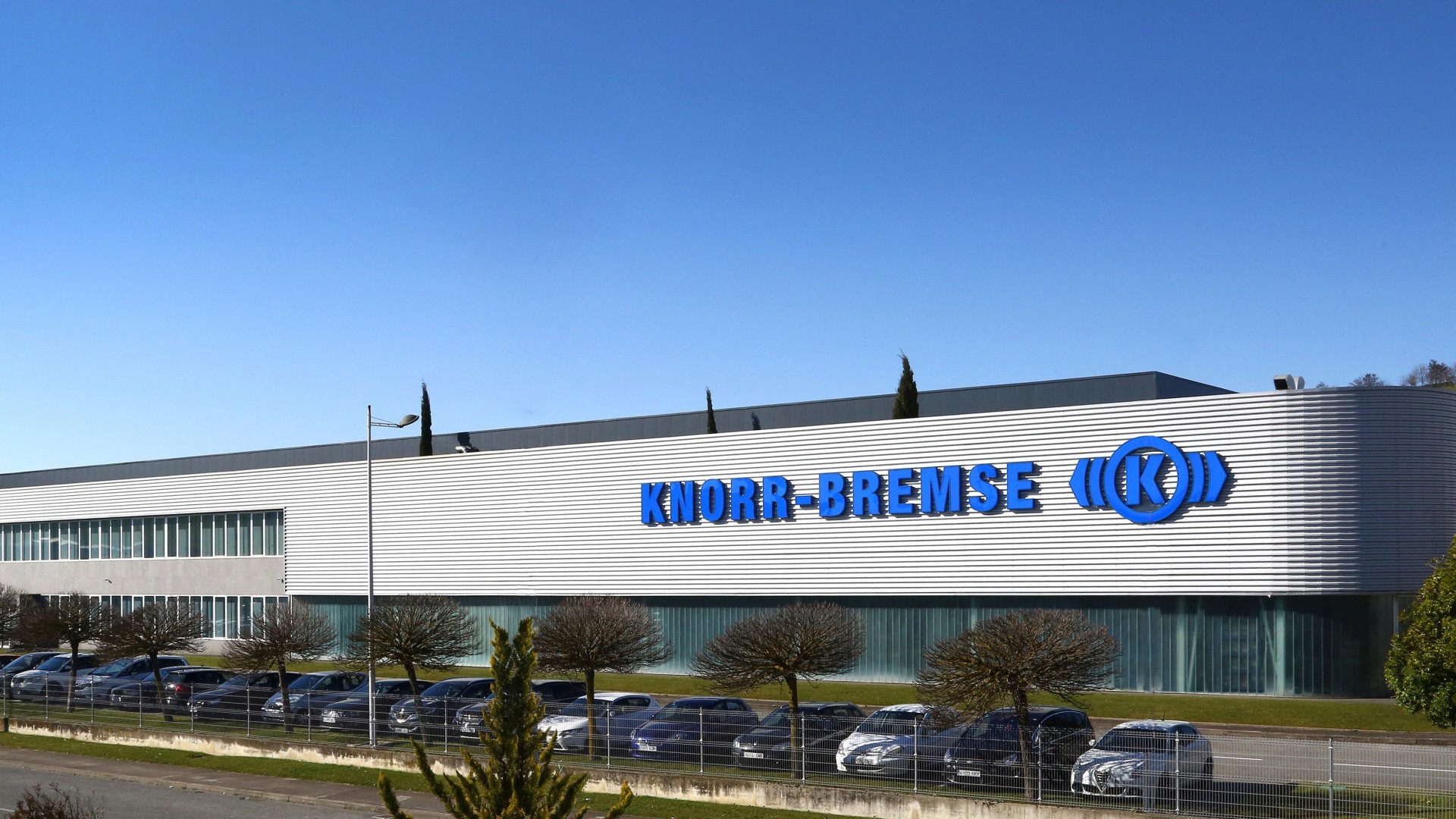 Knorr-Bremse corporate building with clear blue sky.