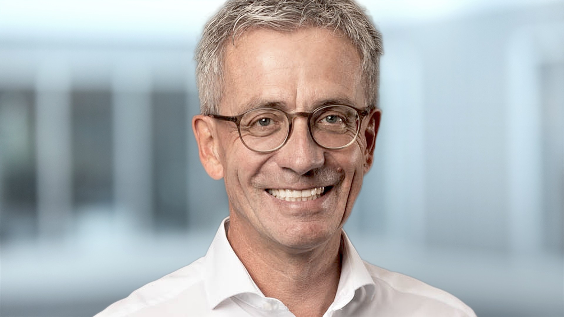 Smiling man wearing glasses and white shirt