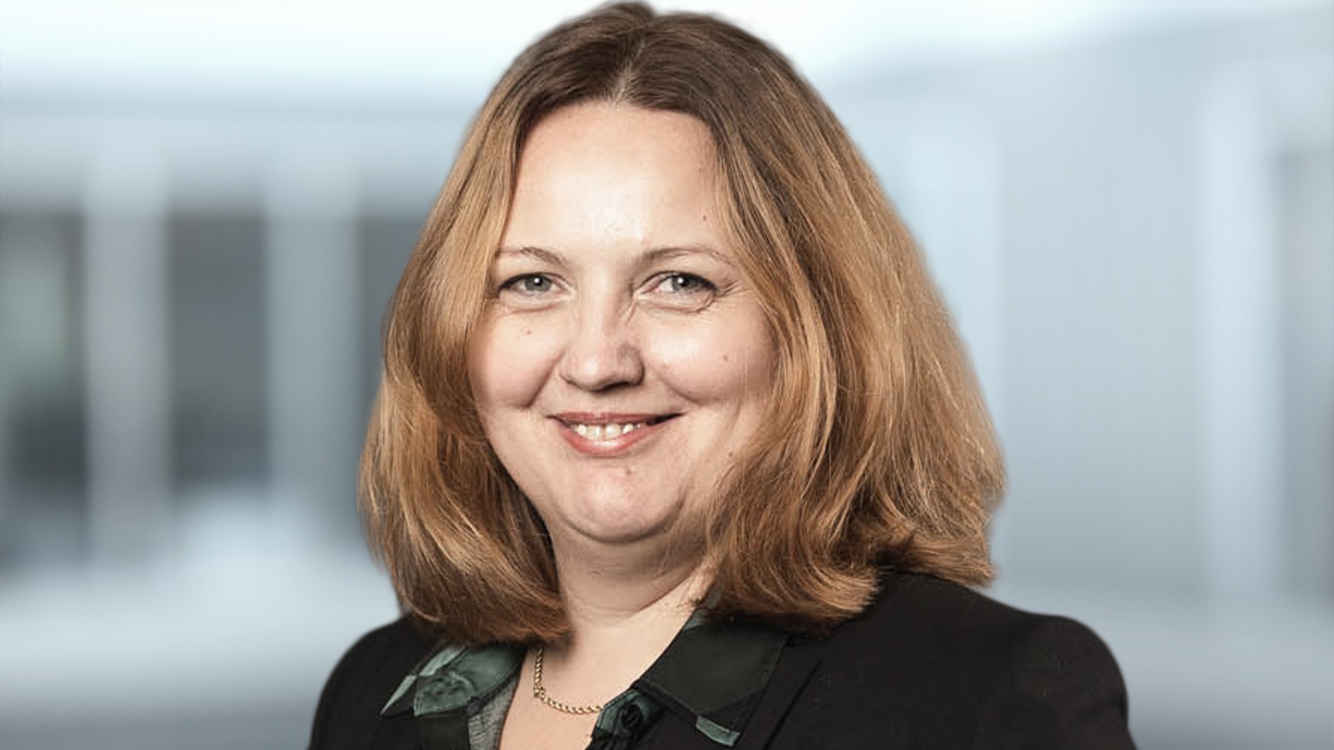 Female professional smiling in a business setting.