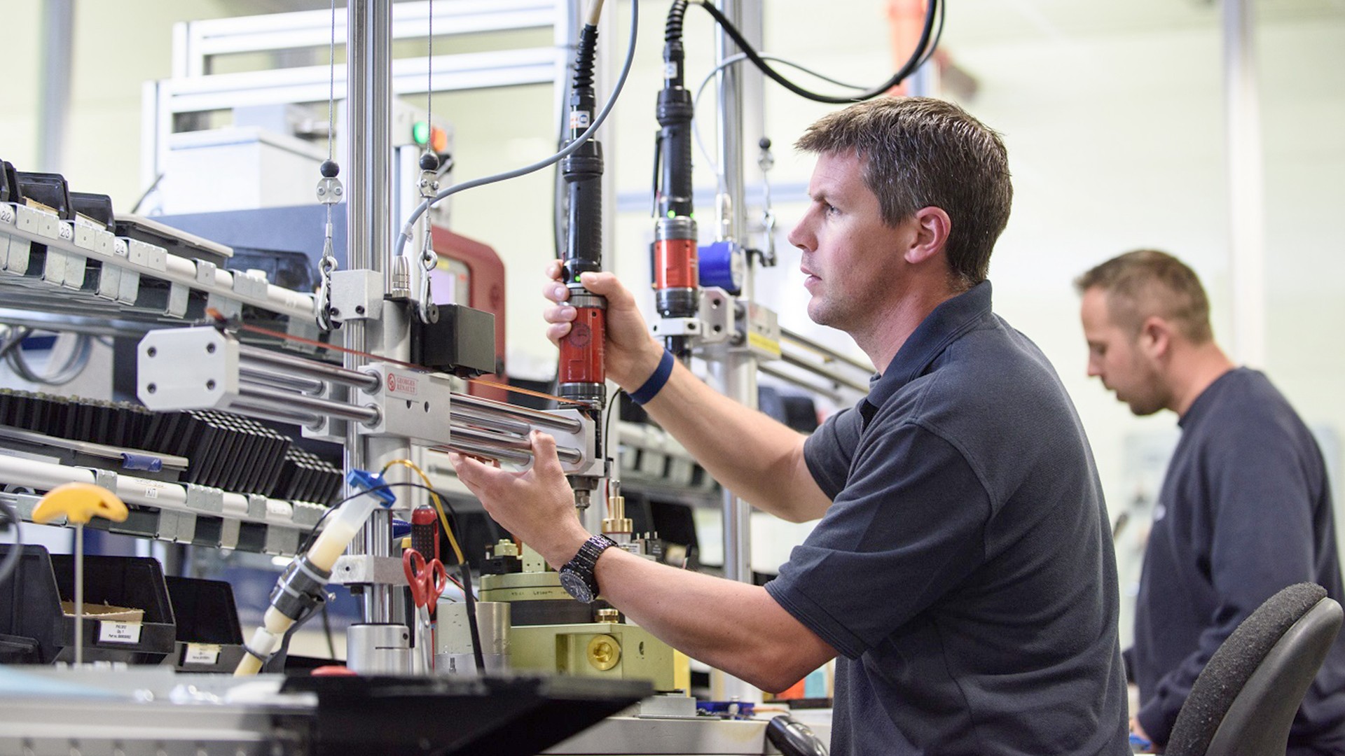 Workers assembling technology in a manufacturing facility.