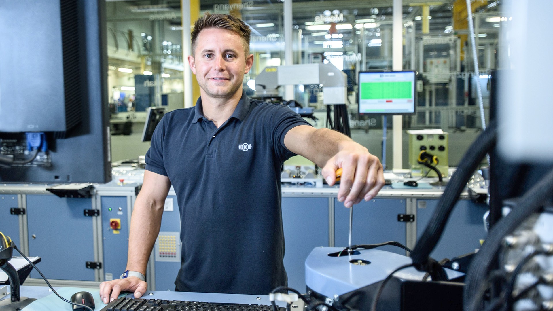 Male technician operating machinery in modern facility.