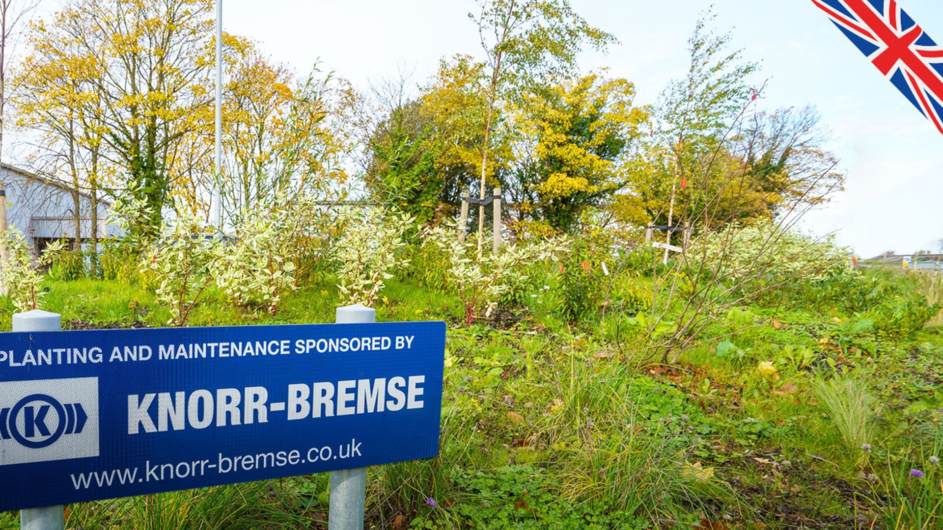 Knorr-Bremse-sponsored planting and maintenance sign in greenery.