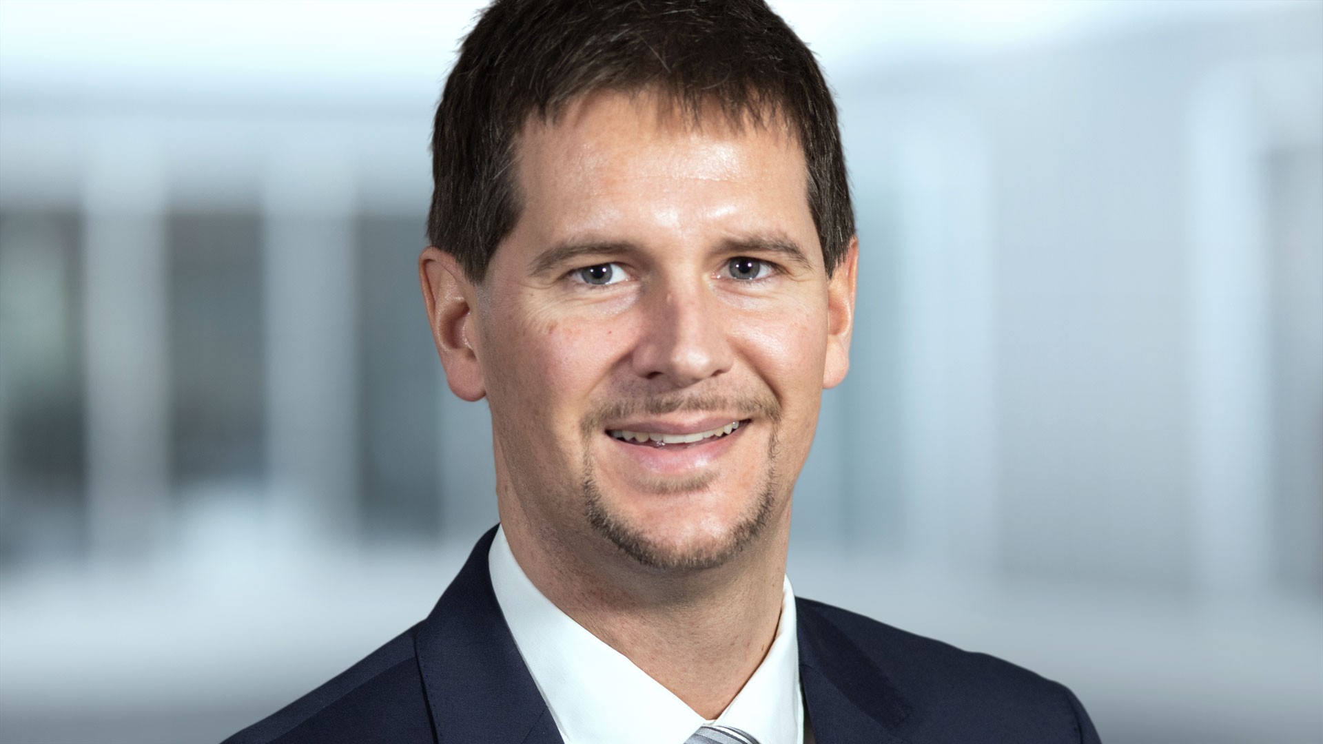 Professional man smiling in business attire.