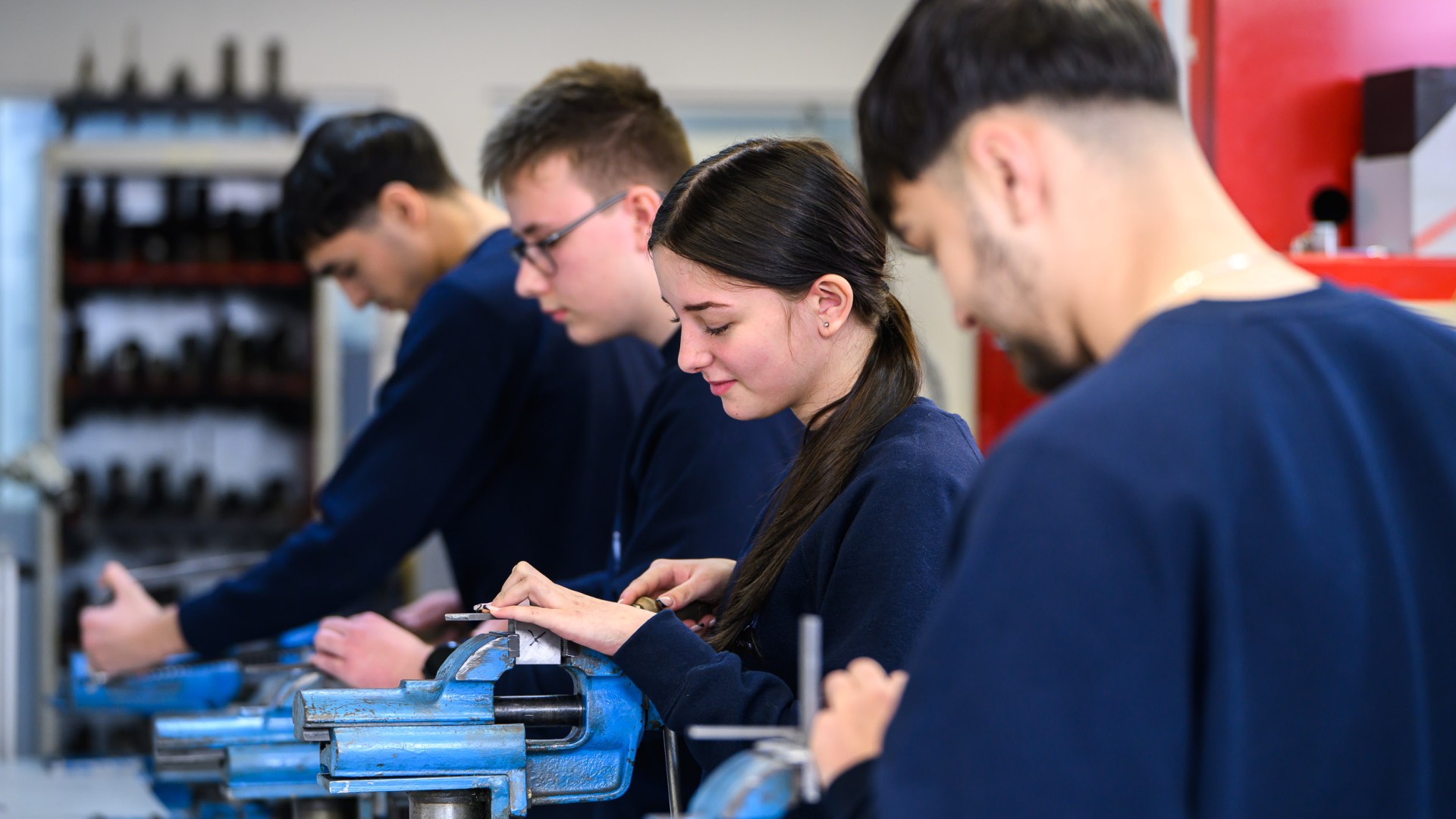 Four trainees working in a workshop.