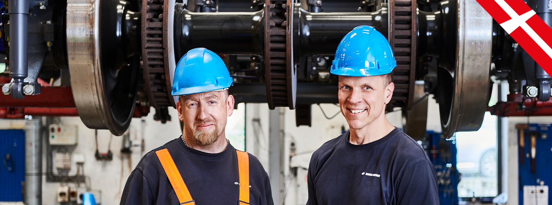 Two people standing in front of a lifting platform.