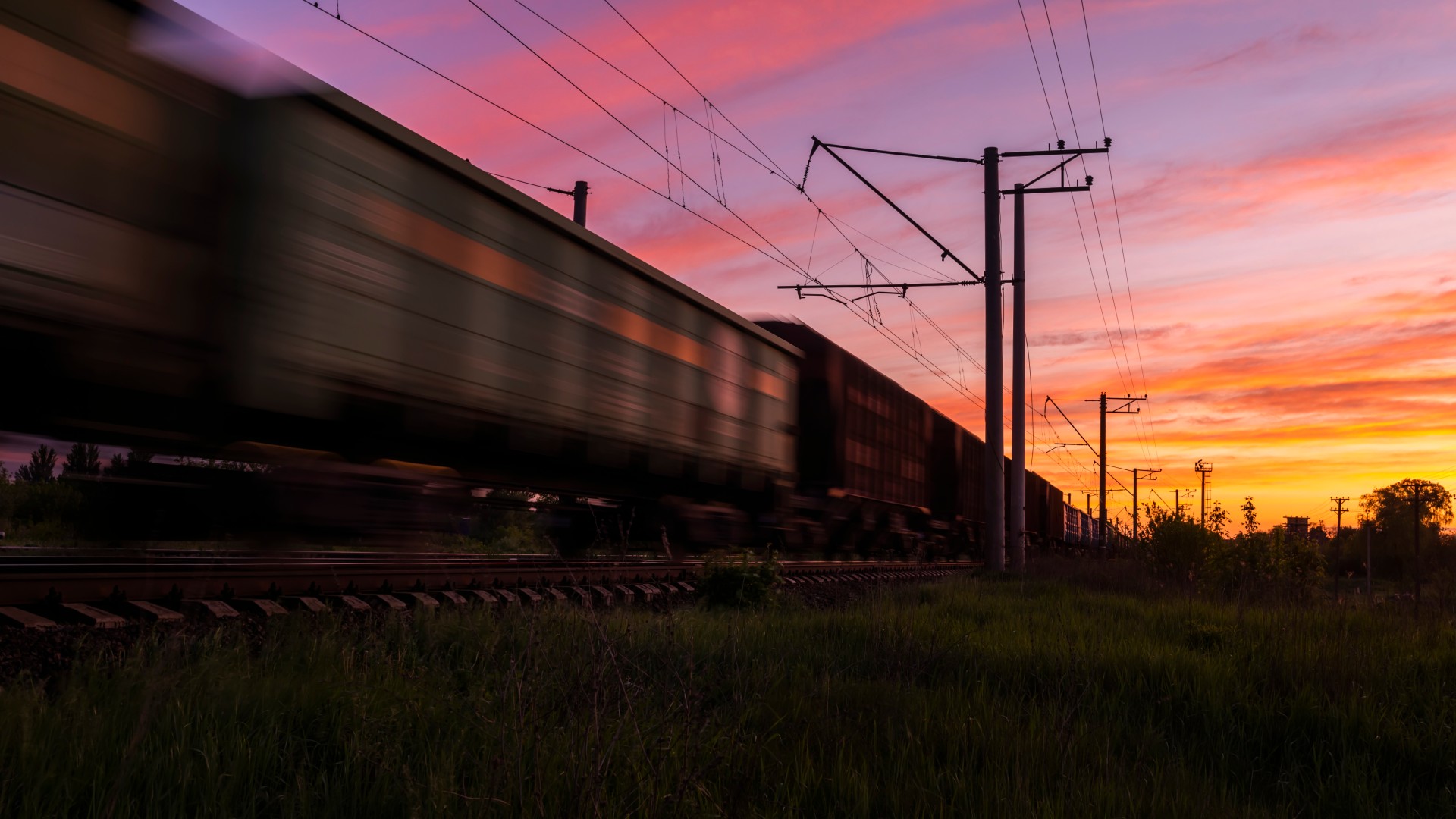 Freight train going through the sundown.