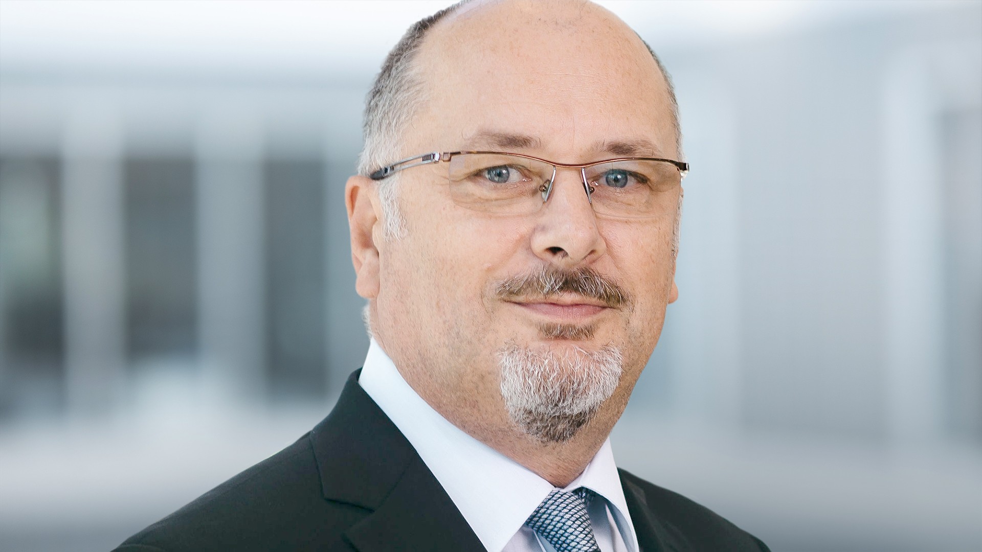 Business executive portrait with glasses and suit.