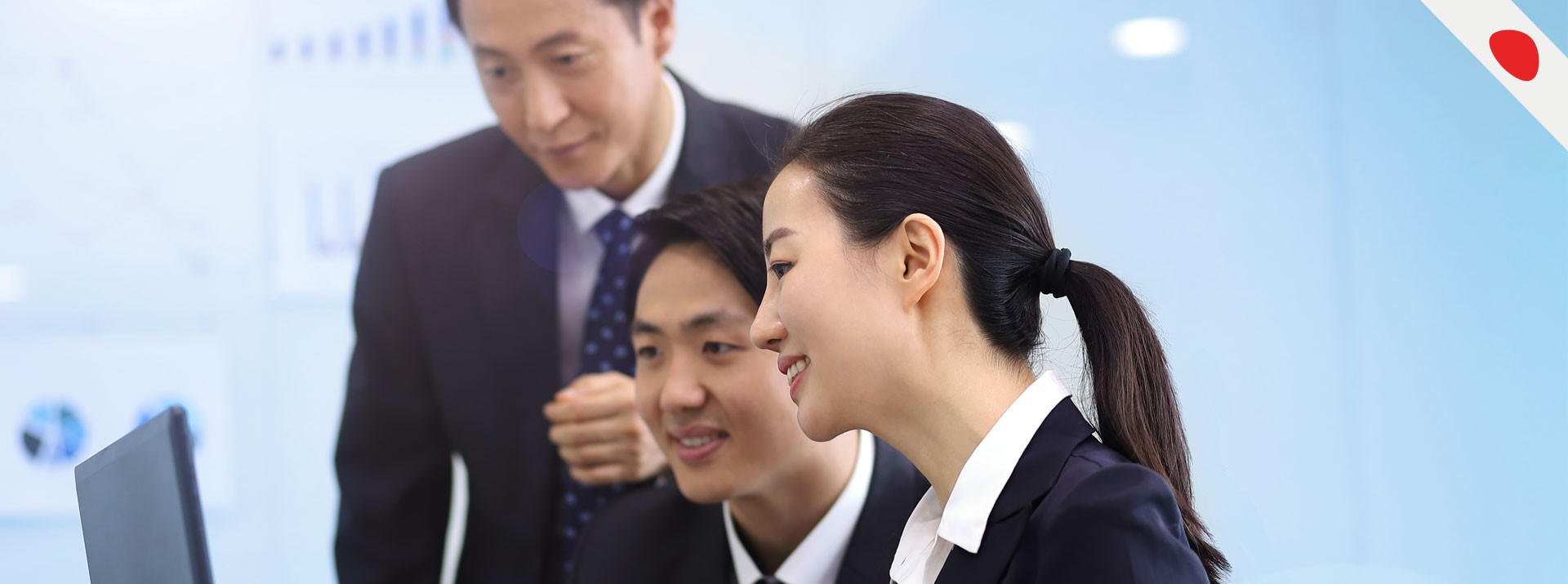 Business professionals collaborating over laptop in office.