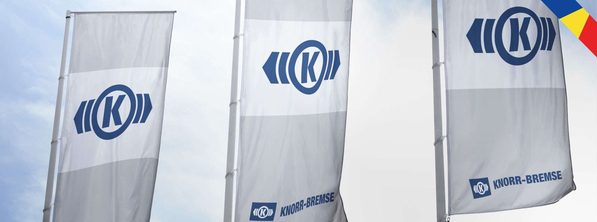 Knorr-Bremse flags displayed against cloudy sky.