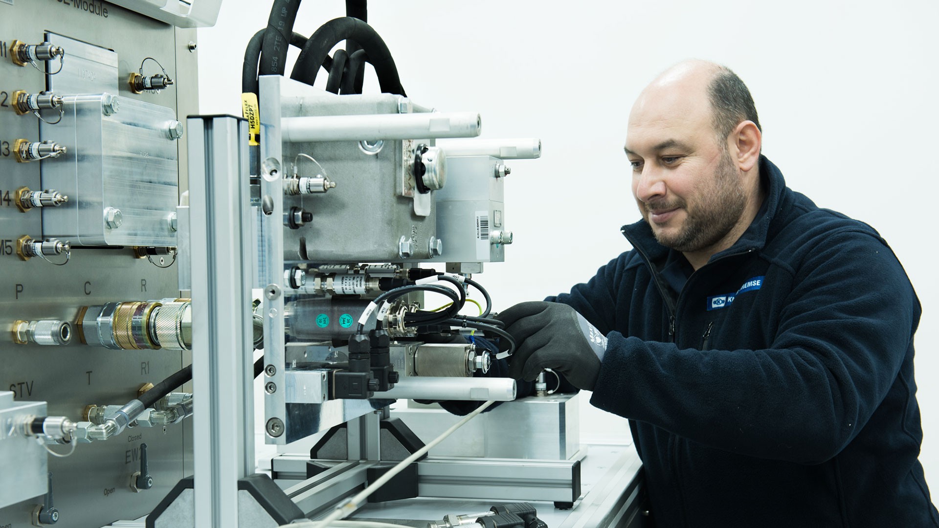 Employee assembling machinery in a technical workspace.