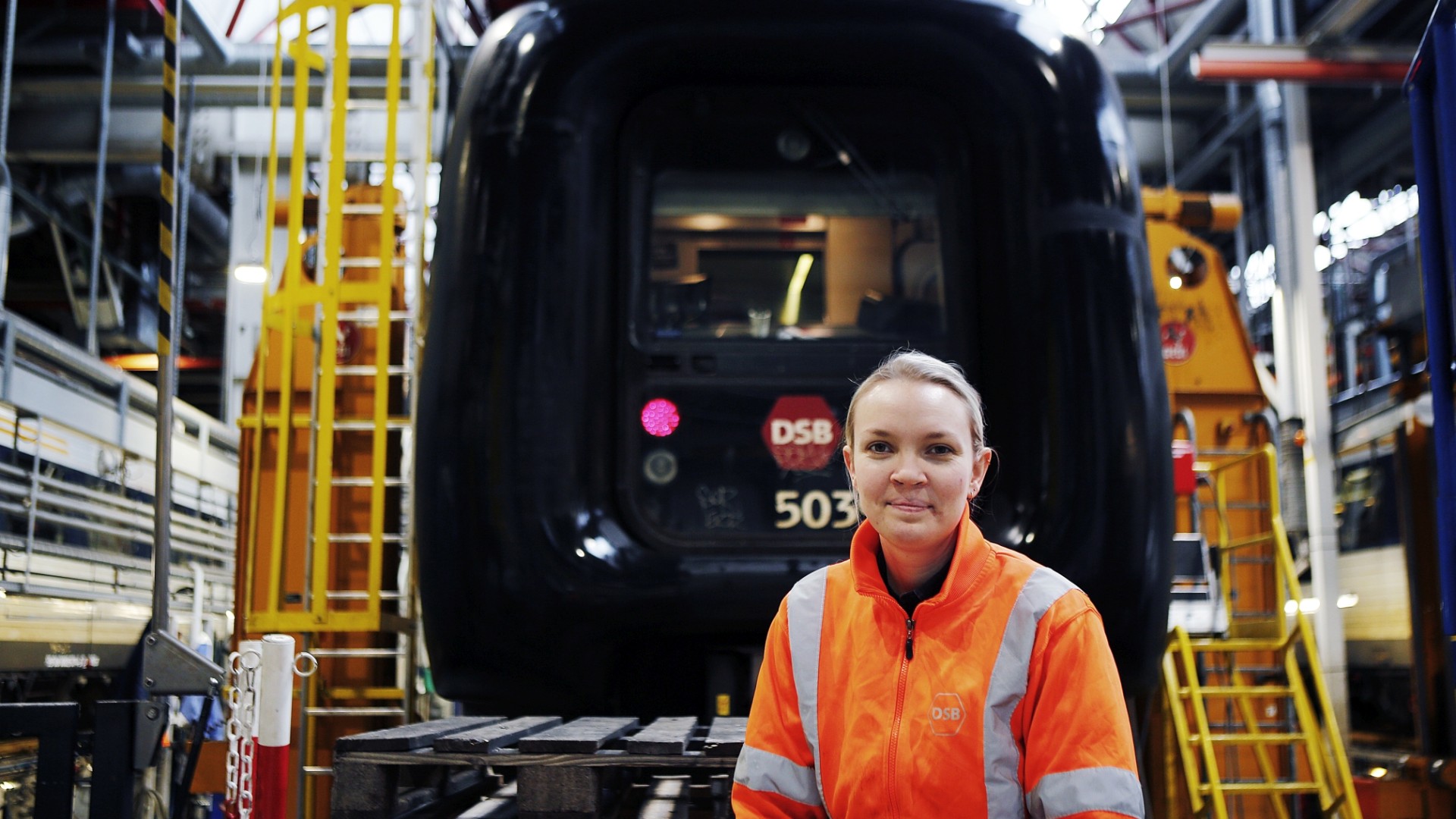 Woman in safety gear at train facility